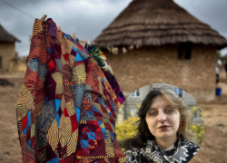 zdjęcie przestawia tkaninę, w tle tradycyjna afrykańska chatka, w kółku zdjęcie autorki